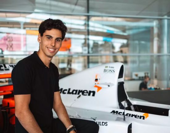 Gabriel Bortoleto, campeão da F3 2023, posa ao lado da McLaren MP4/8 de Ayrton Senna na sede da equipe britânica (Foto: Divulgação)